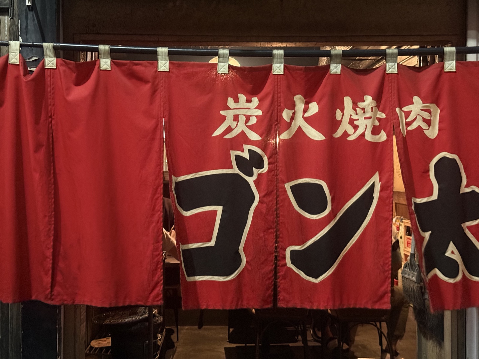 Red noren curtain at a traditional Hiroshima restaurant entrance